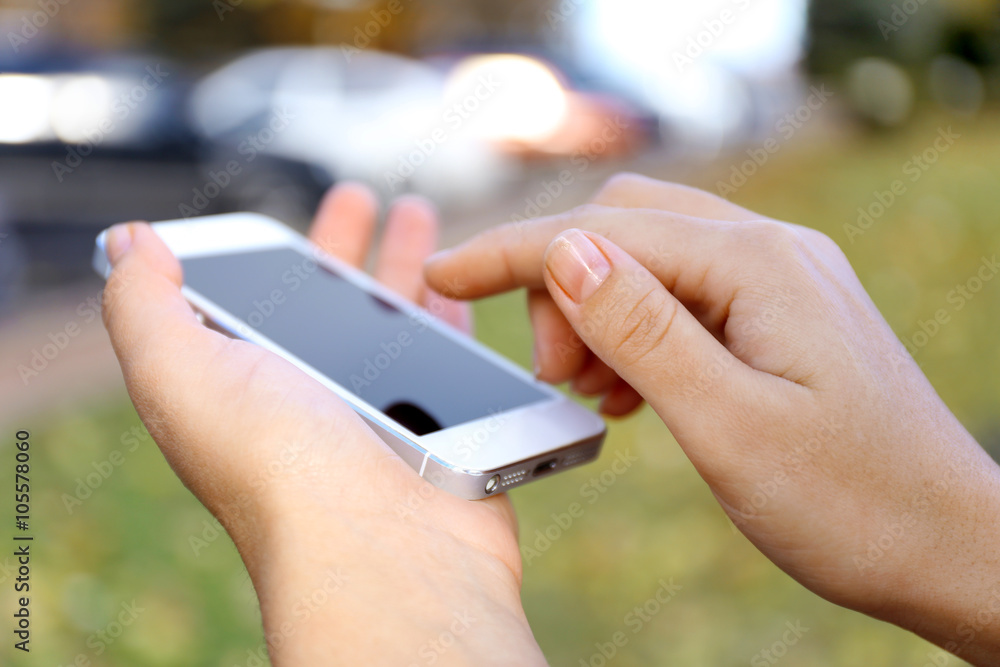 Woman holding smartphone outside