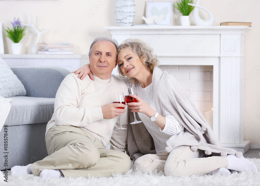 Happy mature couple drinking wine together at home Happy mature couple drinking wine together at home