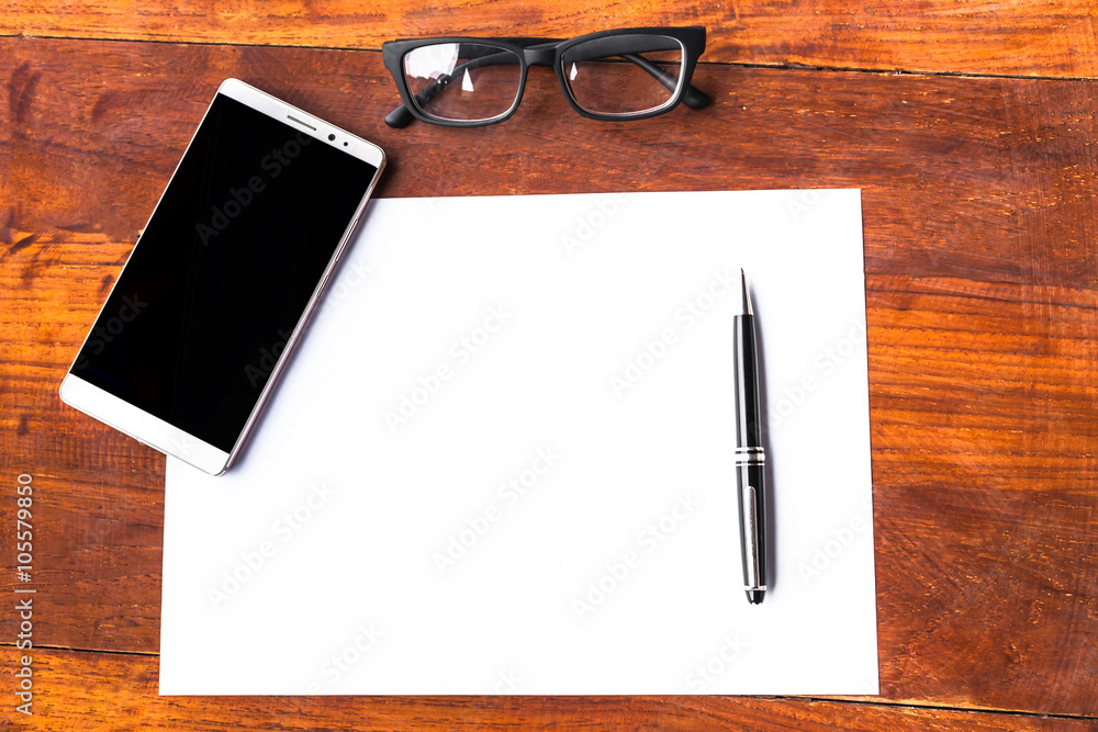 Blank paper with pen and smartphone on wood table concept and Id Blank paper with pen and smartphone on wood table concept and Id