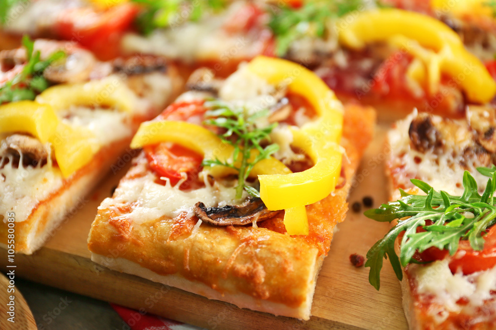 Pieces of delicious pizza on the table, close-up Pieces of delicious pizza on the table, close-up