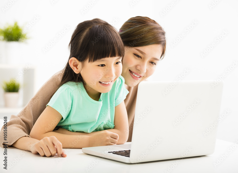 happy Little girl looking at laptop with her mother happy Little girl looking at laptop with her mother