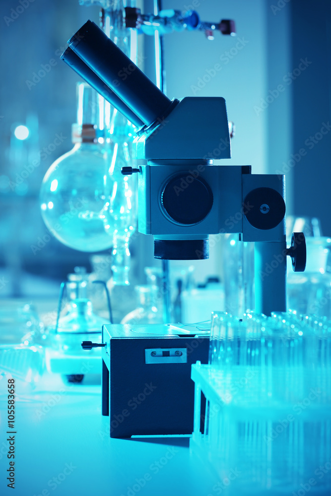 Microscope and different test tubes and flasks in laboratory