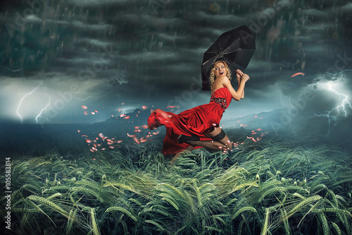 girl in red dress running away from the storm