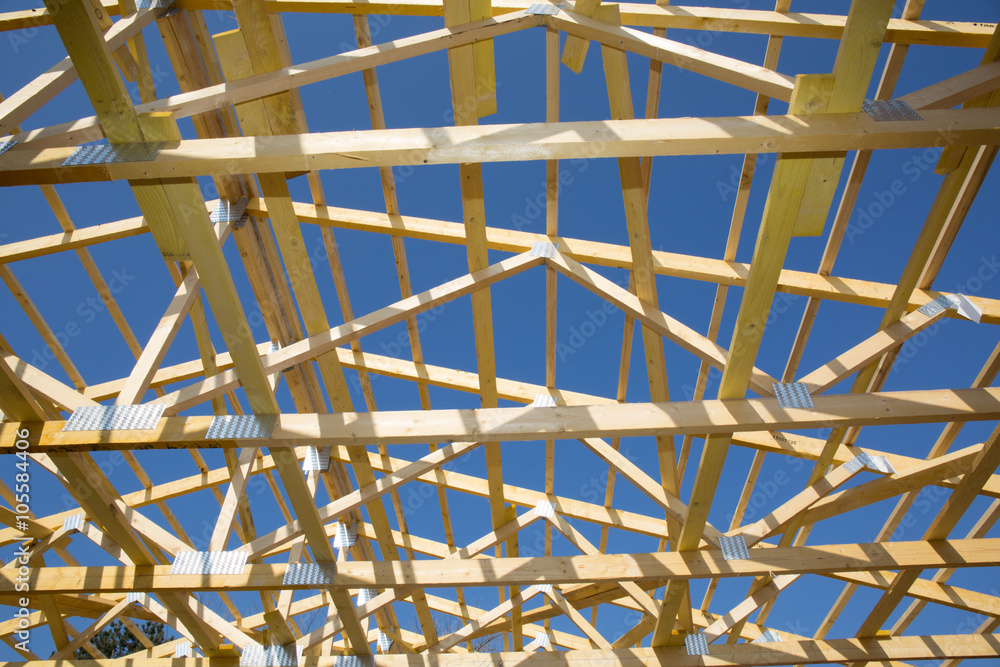 Construction of wooden roof under blue sky on house under coonstruction