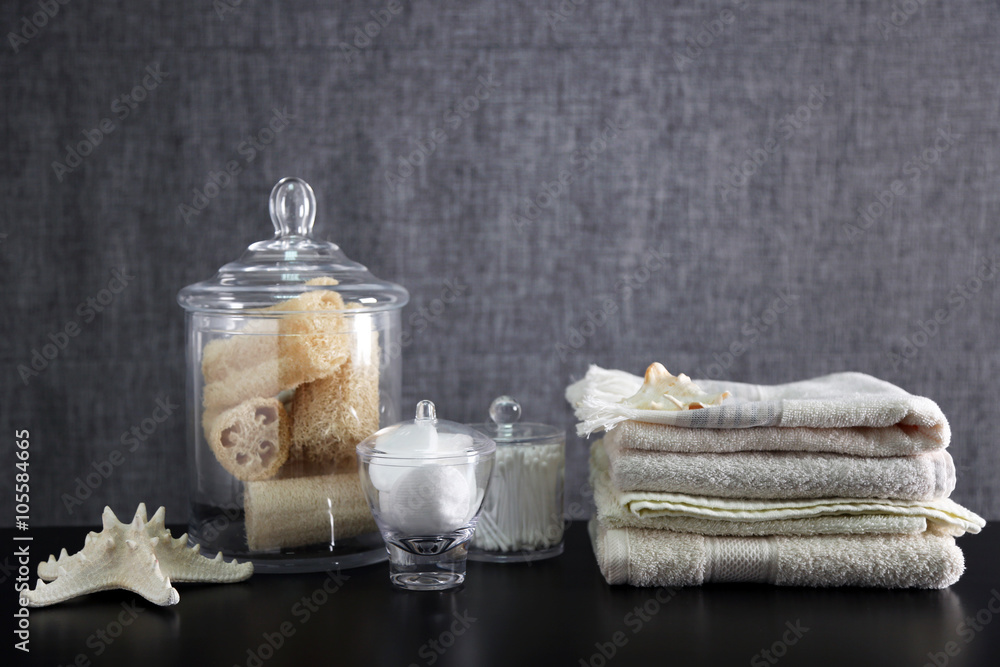Bathroom set with towels, sponges and wisps on grey background