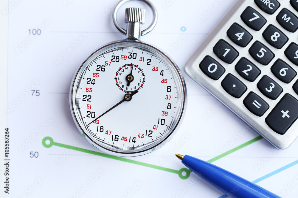 Stopwatch with calculator and pen on paper background Stopwatch with calculator and pen on paper background