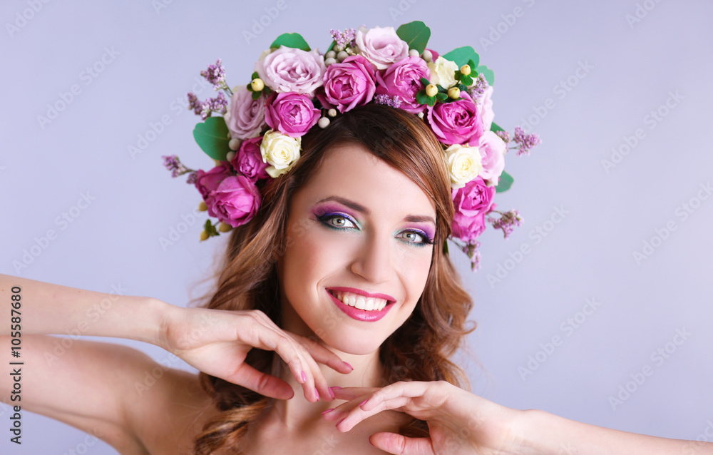 Naklejka premium Beautiful young woman wearing floral headband on a grey background