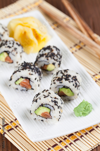 Uramaki sushi with avocado, raw salmon and black sesame