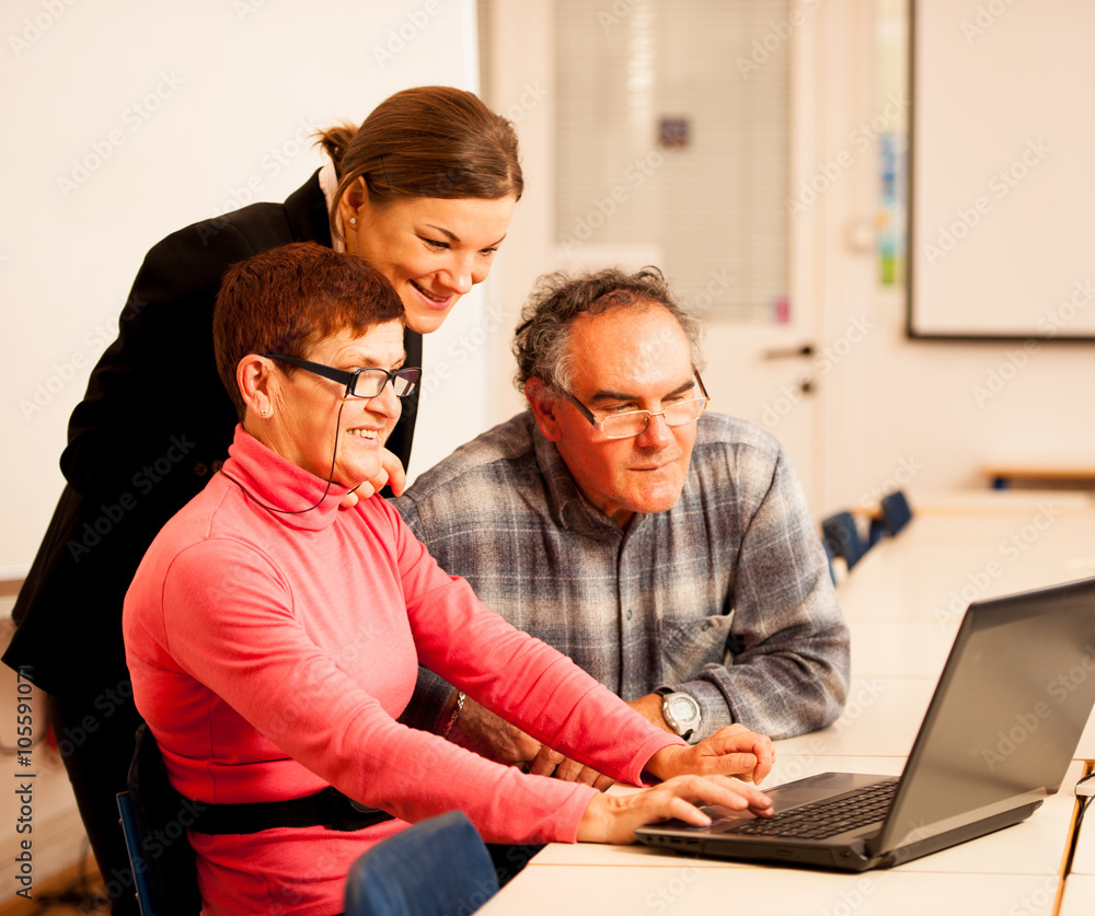 Young woman teaching elderly couple of computer skills. Intergen Young woman teaching elderly couple of computer skills. Intergen