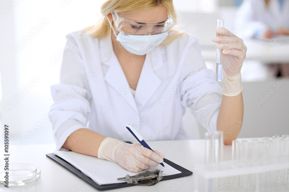 Female scientific research team with clear solution in laboratory Female scientific research team with clear solution in laboratory