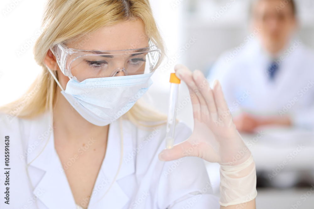 Female scientific research team with clear solution in laboratory Female scientific research team with clear solution in laboratory