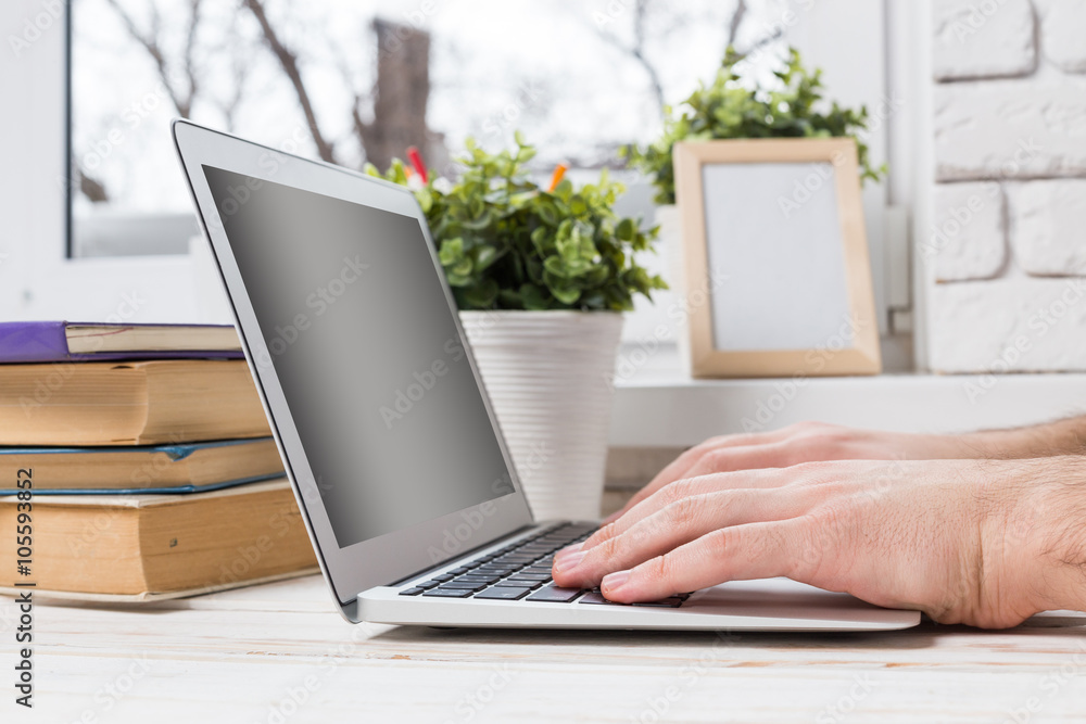 Man's hands using laptop with blank screen Man's hands using laptop with blank screen
