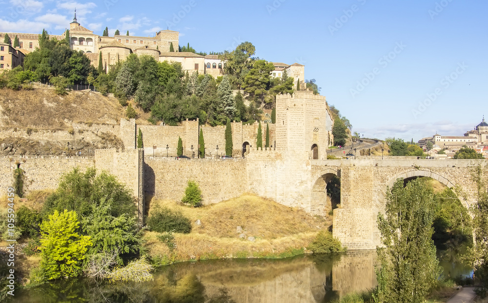 background cityscape view of the ramparts Toledo Alcantara bridge over the Tagus river and the Alcazar