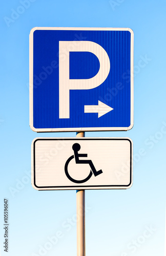 Close-up of a handicapped parking sign against blue sky