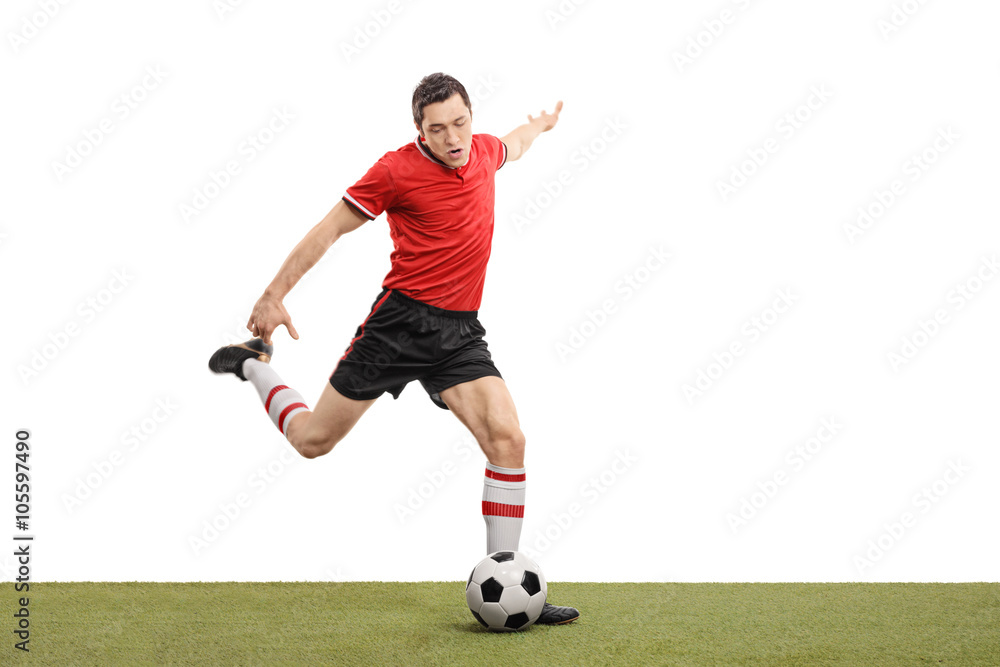 Obraz premium Young football player kicking a ball