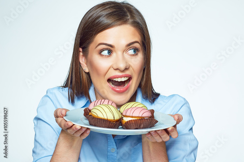 Woman holding plate with cookies and she wants to eat them.