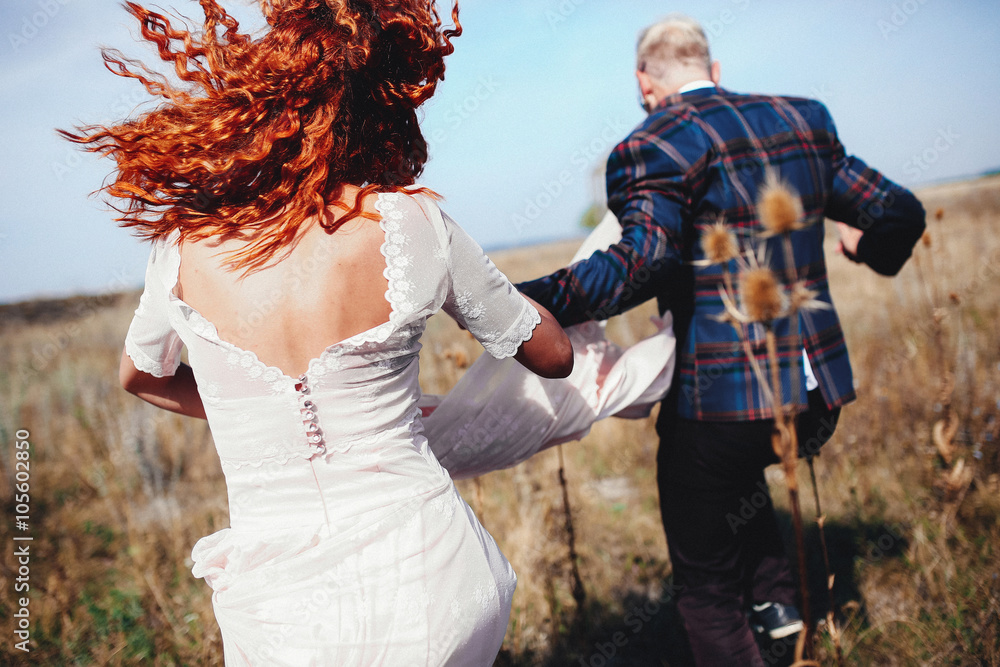 Redhead bride is escaping with his groom