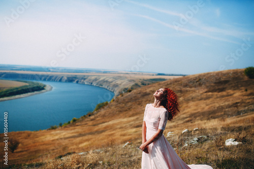 Beautiful bride on the riverbank in the wedding day