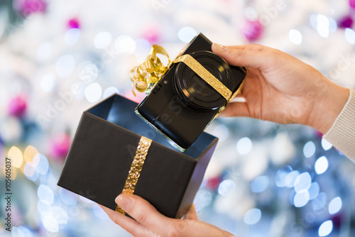 Woman discovers a digital compact photo camera  christmas gift