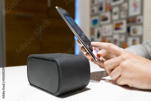 Woman connect their smart-phone to speakers. Nfc, bluetooth photo