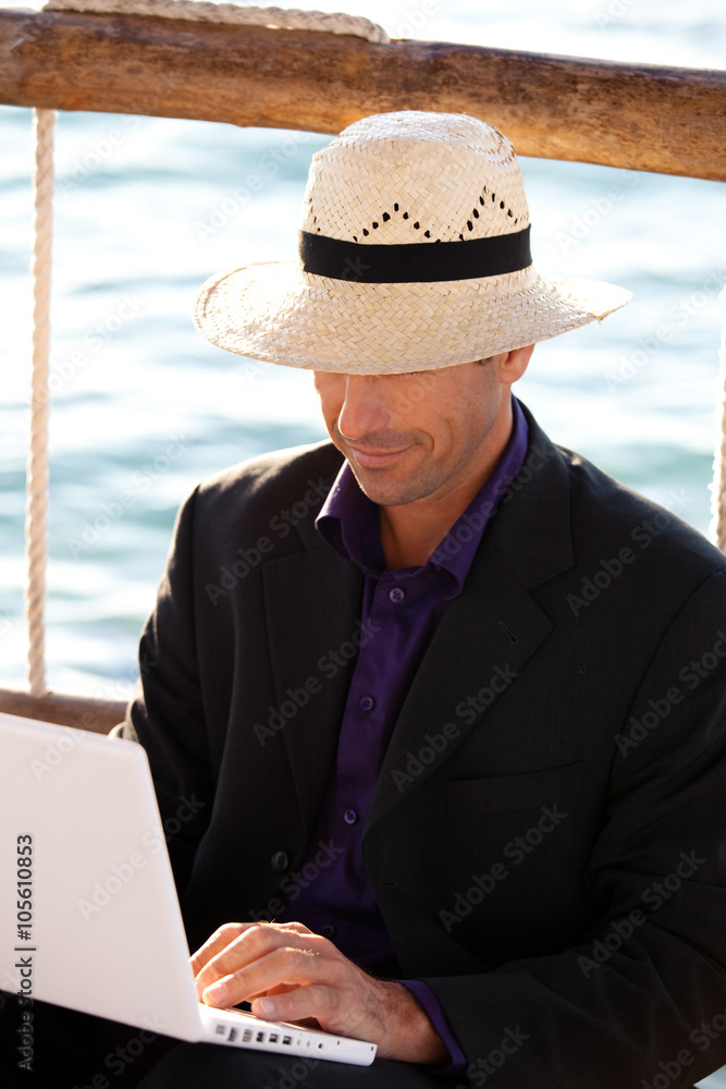 homme d'affaire heureux à la mer avec son ordinateur 