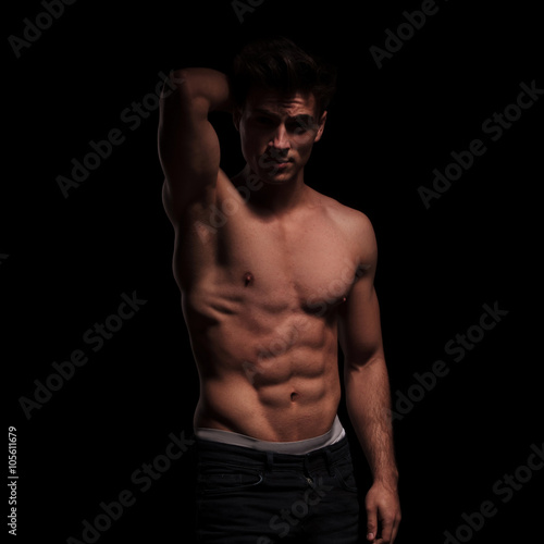  topless, muscular man raising his arm