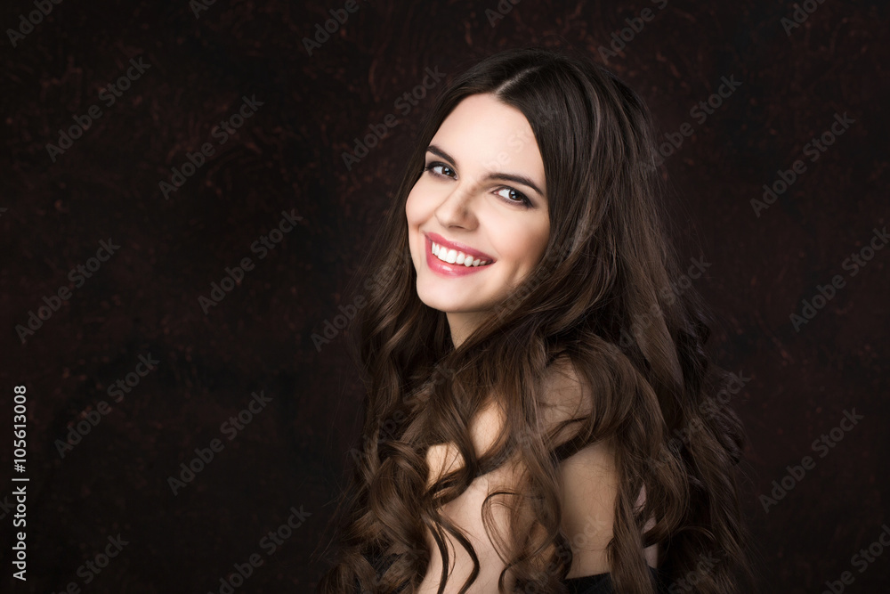 Fototapeta premium Portrait of a beautiful young woman with healthy long hair and beautiful smile on a dark background.