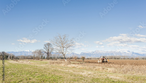 Agricultural landscape with tractor plowing.