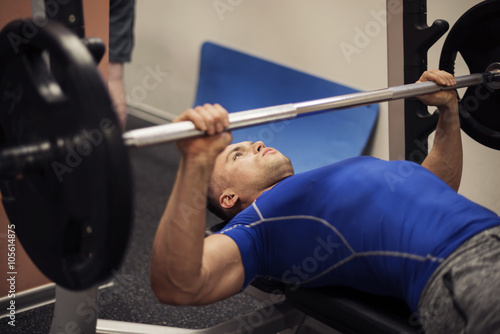 Focused man doing workout on weight bench