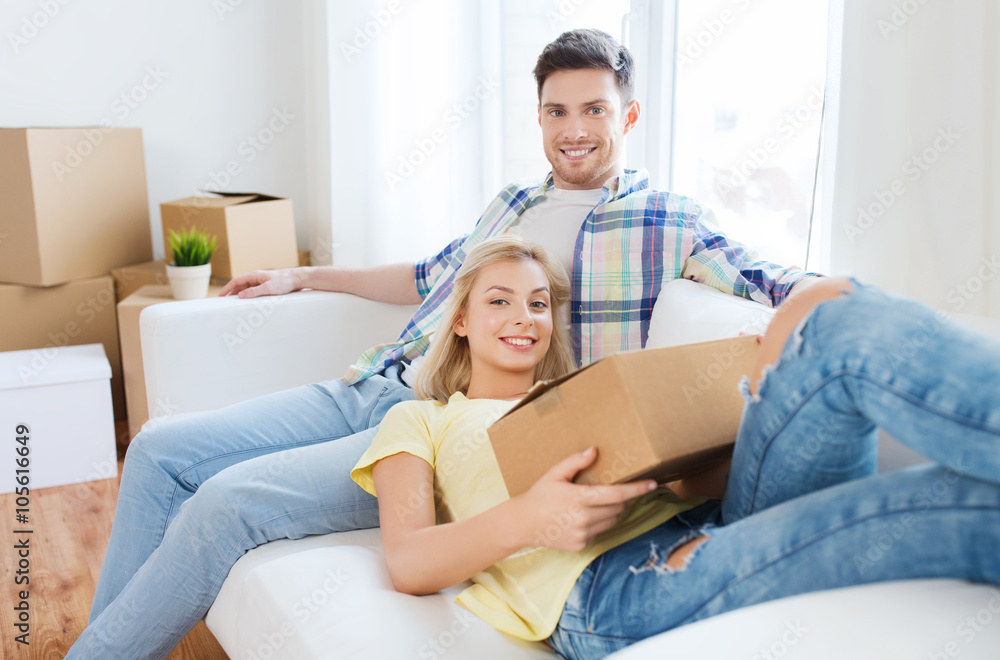happy couple with big cardboard boxes at new home