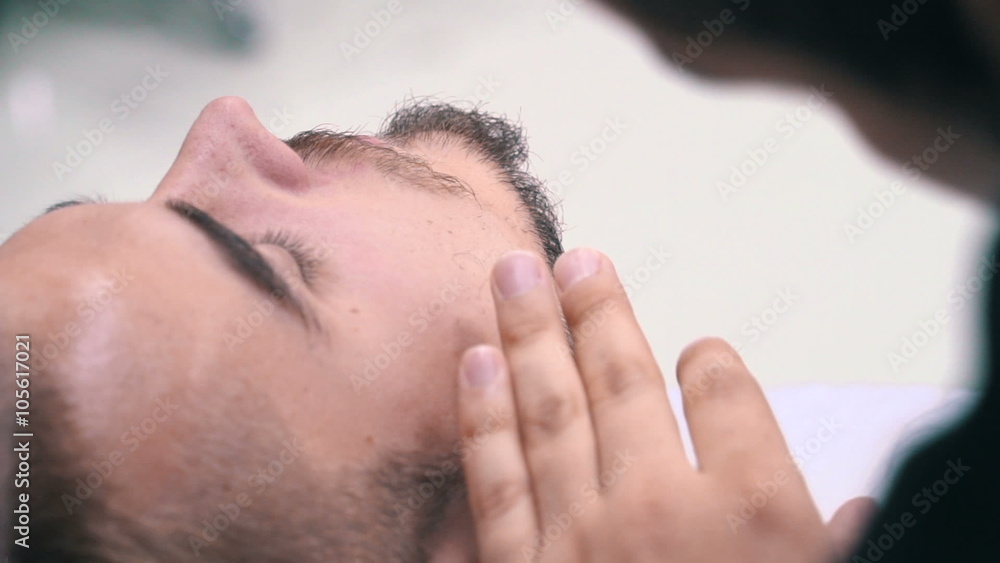 Barber cuts the beard of the client with blade at a barber shop Barber cuts the beard of the client with blade at a barber shop