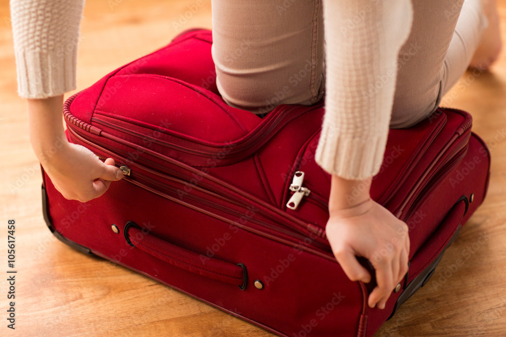 close up of woman packing travel bag for vacation