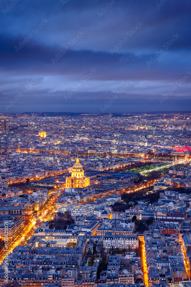 Aerial view of streets and avenues of Paris at twilight.The Invalides and Army Museum are at the center. The Arch of Triumph is in the distance. France