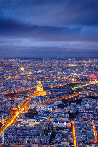 Aerial view of streets and avenues of Paris at twilight.The Invalides and Army Museum are at the center. The Arch of Triumph is in the distance. France