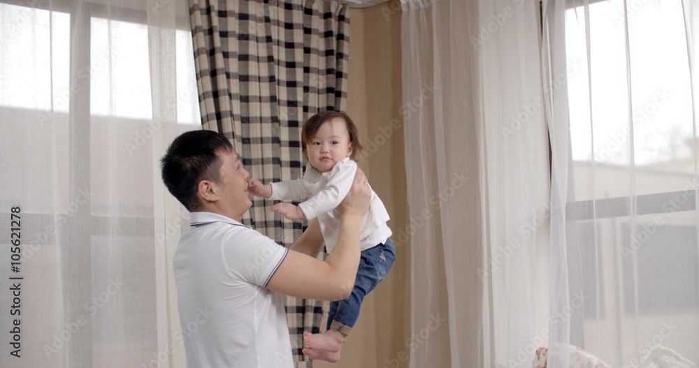 young Asian father playing with her baby holding, happy emotions, baby laughing slow motion young Asian father playing with her baby holding, happy emotions, baby laughing slow motion