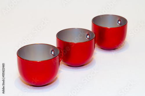 three red empty cups of tea (coffee) on white background