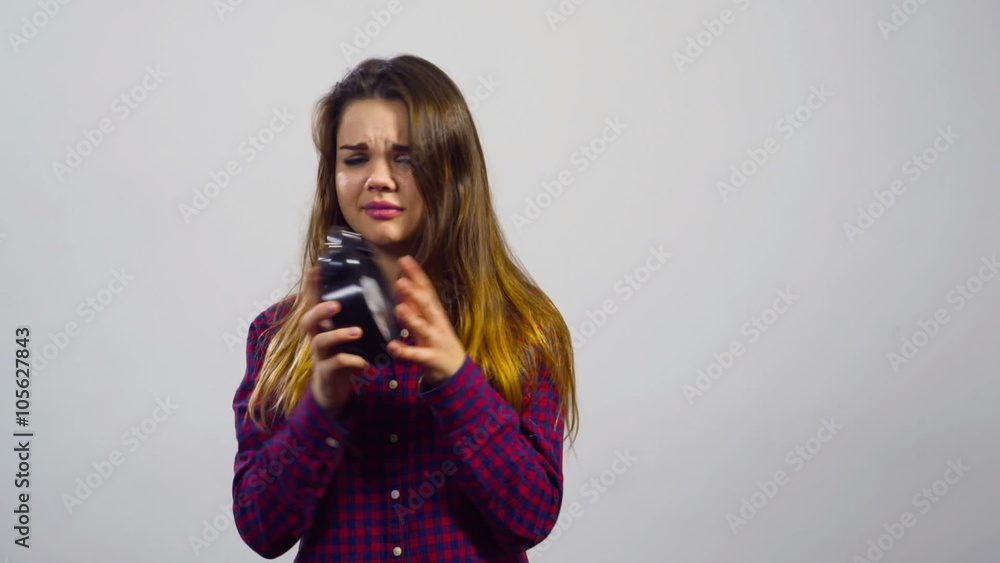 young girl with alarm clock in front of white background young girl with alarm clock in front of white background