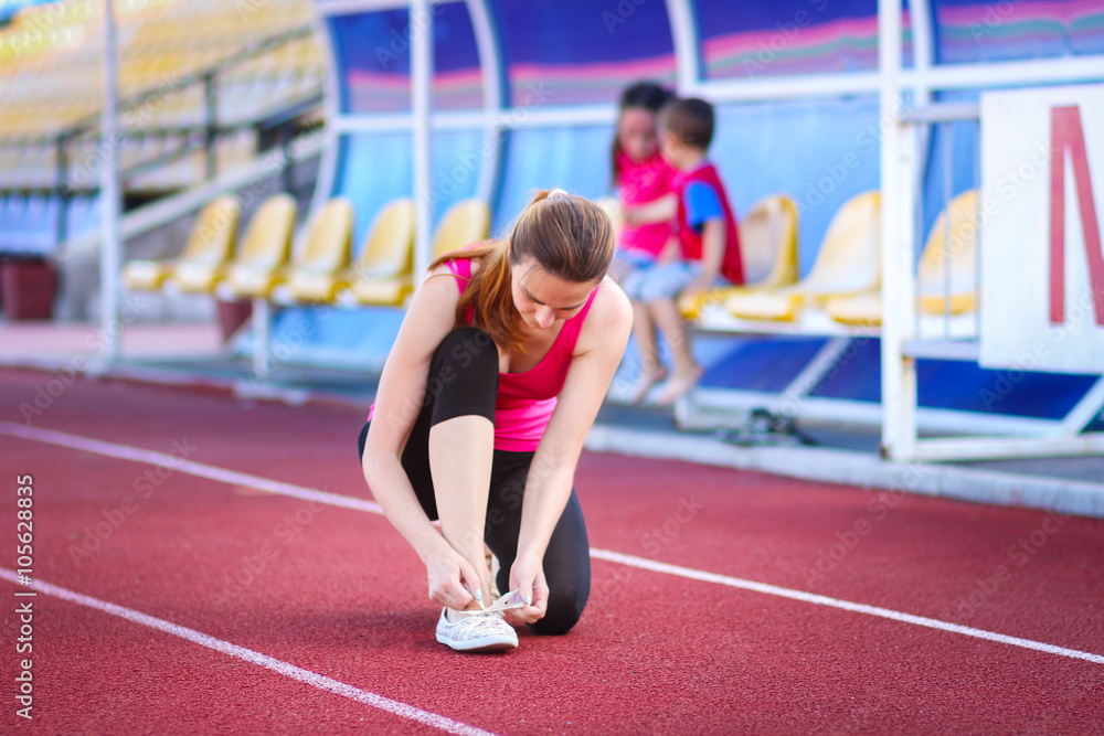 Girl at the stadium to tie shoelaces Girl at the stadium to tie shoelaces