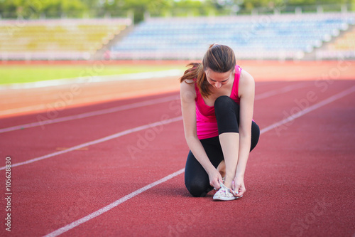 Girl at the stadium to tie shoelaces
