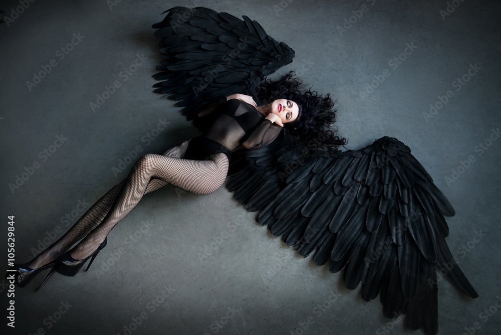 Fallen black angel with wings. Sexual woman Stock Photo