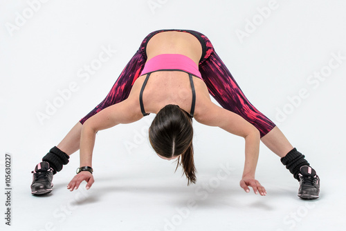 sporty girl in pink form doing exercises isolated on white background