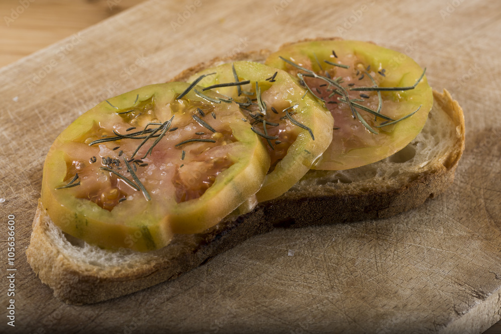 Italian antipasto called Bruschetta. slice of toasted bread topped with tomato, olive oil and rosemary.