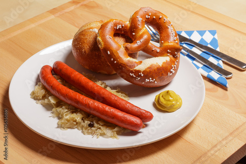 Debreziner auf Sauerkraut mit Semmel und Breze