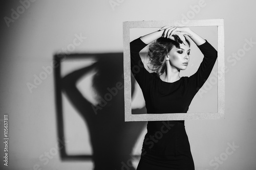    harismatic woman frame in his hands  fashion pose  black and white photo  studio shooting negativity  loneliness  divorce  pain  depression