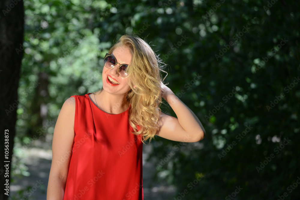 beautiful young woman in sunglases near the summer park