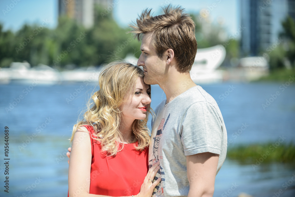Young happy couple hugging and laughing on river background Young happy couple hugging and laughing on river background