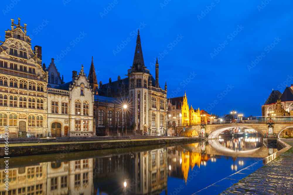 Picturesque medieval building and St Michael's Bridge on the quay Graslei in Leie river at Ghent town at evening, Belgium