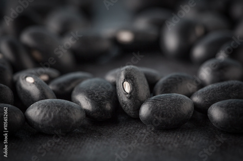 Black turtle beans on dark surface extreme closeup