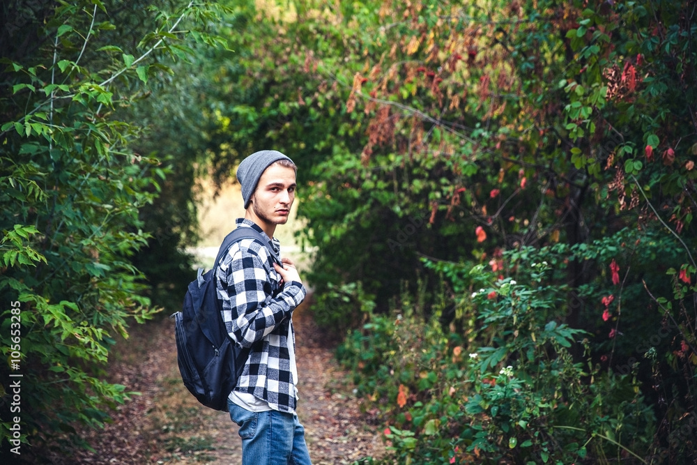 Portrait of young handsome man with backpack wanderer walk in the woods Portrait of young handsome man with backpack wanderer walk in the woods
