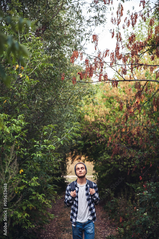Portrait of young handsome man with backpack wanderer walk in the woods Portrait of young handsome man with backpack wanderer walk in the woods